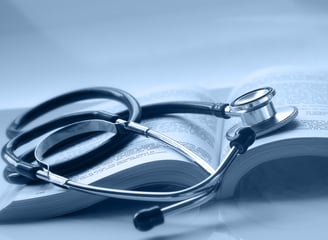 An open medical book with a stethoscope on top of it