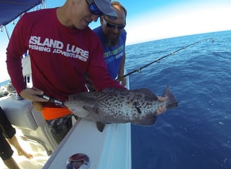 man with fish he caught on boat