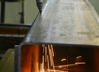 automation robot plasma cutting through a metal beam