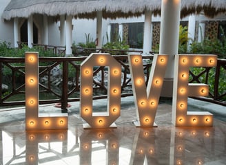 a large light up letters spelling love in front of a house