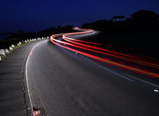 a car driving down a road at night with solar powered illumination