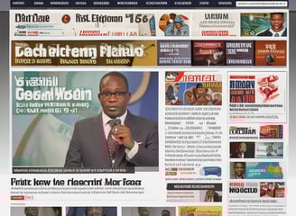 A hand holding a smartphone displaying a news website, with a blurred large computer screen in the background also showing similar content. The webpage on the phone features articles with images and text.