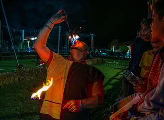 l'artista sta eseguendo tecniche di manipolazione fuoco con numero di mangiafuoco