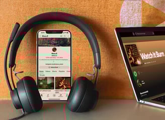 a laptop and headphones on a table with a phone showing Moss.E's youtube page and music