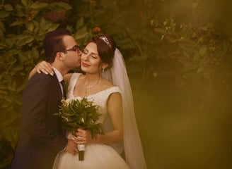 a bride and groom kissing in a garden