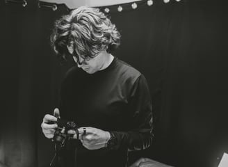 A man setting up a camera in a podcast studio.