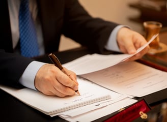 a man in a suit jacket and tie dyes a pen and a pen