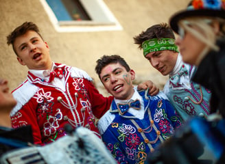 a group of people dressed in costumes and singing during carnival