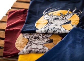 Two graphic t-shirts featuring a stylish deer smoking a pipe, printed design