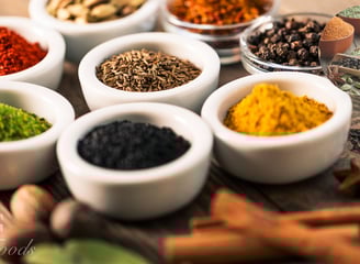 Various herbs and spices in white bowls
