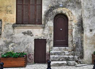 a building with a door and a bench in front of it
