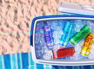 Cerveja Aurora em 3D, lata vermelha em cooler com gelo, ambiente de praia.