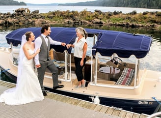 a bride and groom standing on an eco-friendly all electric boat wedding anniversary proposal