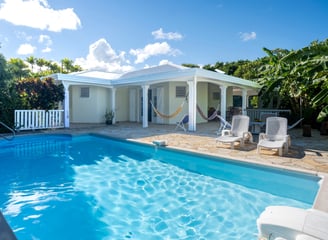 A house in Martinique with a pool, hammocks, and banana trees
