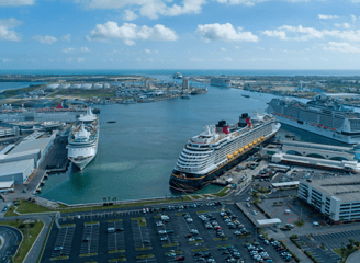 a cruise ship docked in a harbor with a cruise ship in the background