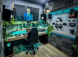 setup gamer/tabalho com tres monitores, um tv acima, espumas acusticas nas paredes e algumas plantas