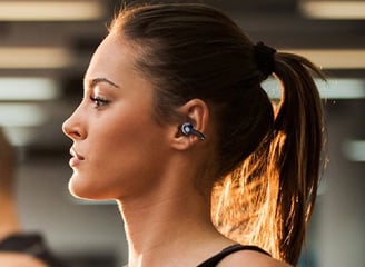 a woman with OWS earphones on a treadmill
