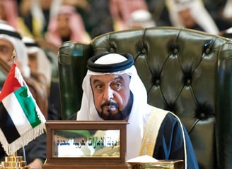 Khalifa bin Zayed Al Nahyan in a suit and sitting on a chair