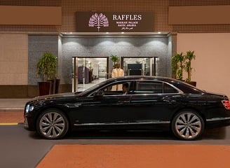 Voiture avec chauffeur privé devant un hôtel confortable, pour votre Omra sur mesure.