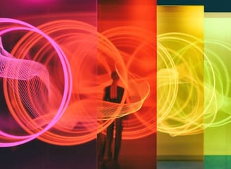 a person standing in front of a rainbow colored light