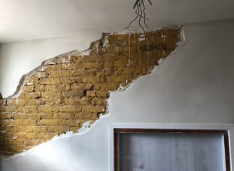 Decoratief stucwerk met zichtbare bakstenen.