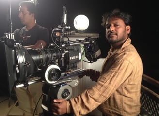 a man in a brown shirt is holding a camera