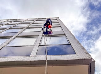 a person in a blue shirt is hanging from a rope