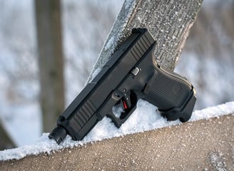 Glock pistol resting on a snow covered fence