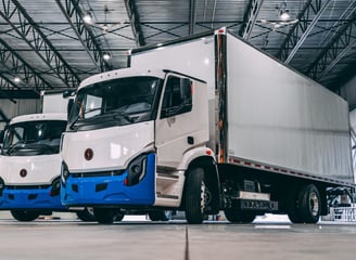 two trucks parked in a warehouse with a large warehouse