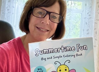 Photo of Laura Kane holding the Summertime Fun coloring book
