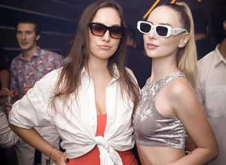 two women in sunglasses and sunglasses standing next to each other