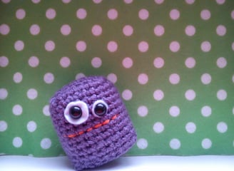 a purple crochet with eyes and eyes, a small purple crochet