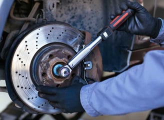 man with a car tool fixing a brake.