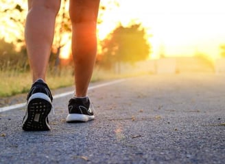 a person walking on a road with a person wearing a pair of sneakers