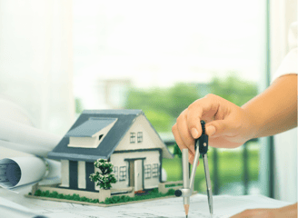 a person holding a keychain and a house model