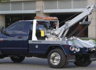 A blue tow truck with silver equipment