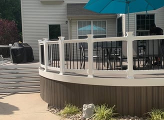 a patio with a new deck remodel and a blue umbrella