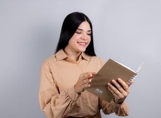 a woman in a brown shirt is holding a book