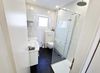 bathroom with a shower, sink and washing machine