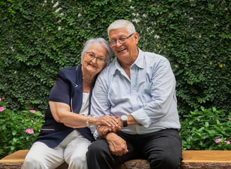Reencuentro emotivo entre hermanos mayores, sentados juntos, sonriendo con alegría, celebrando su unión tras años de separaci
