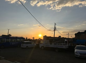 a bus stop at sunset with the sun setting