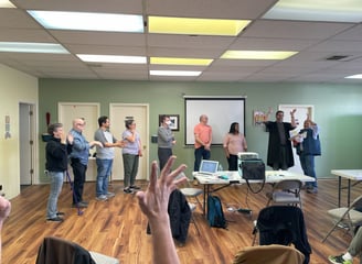 Hand raised in center of photo with people lined up in the background