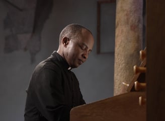 an african man from Tanzania plays the piano enjoing it