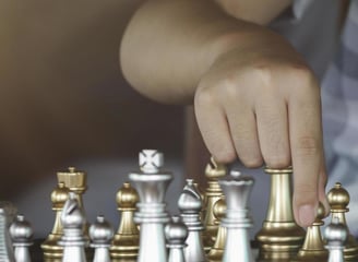 A chess student is moving chess pieces on a chess board for tactics training
