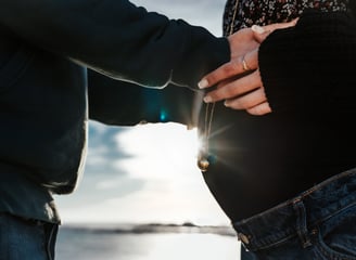 a pregnant woman holding her belly with her man
