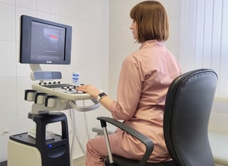 doctor sitting behind ultrasound machine