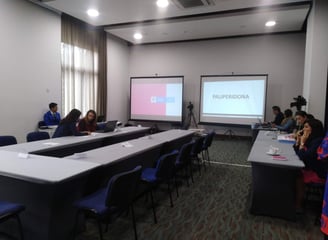 a group of people sitting at a table with a projector