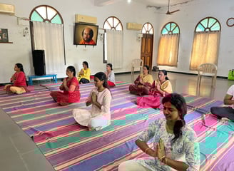 a group of people meditating on a rug in a room