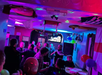 a group of people standing around a table with balloons