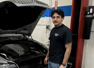 a man standing in front of a car with a car in the background